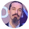 Man with a beard and mustache wearing a suit jacket and collared shirt.