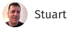 Portrait of a man with short dark hair and a neutral expression on a white background with the name Stuart.